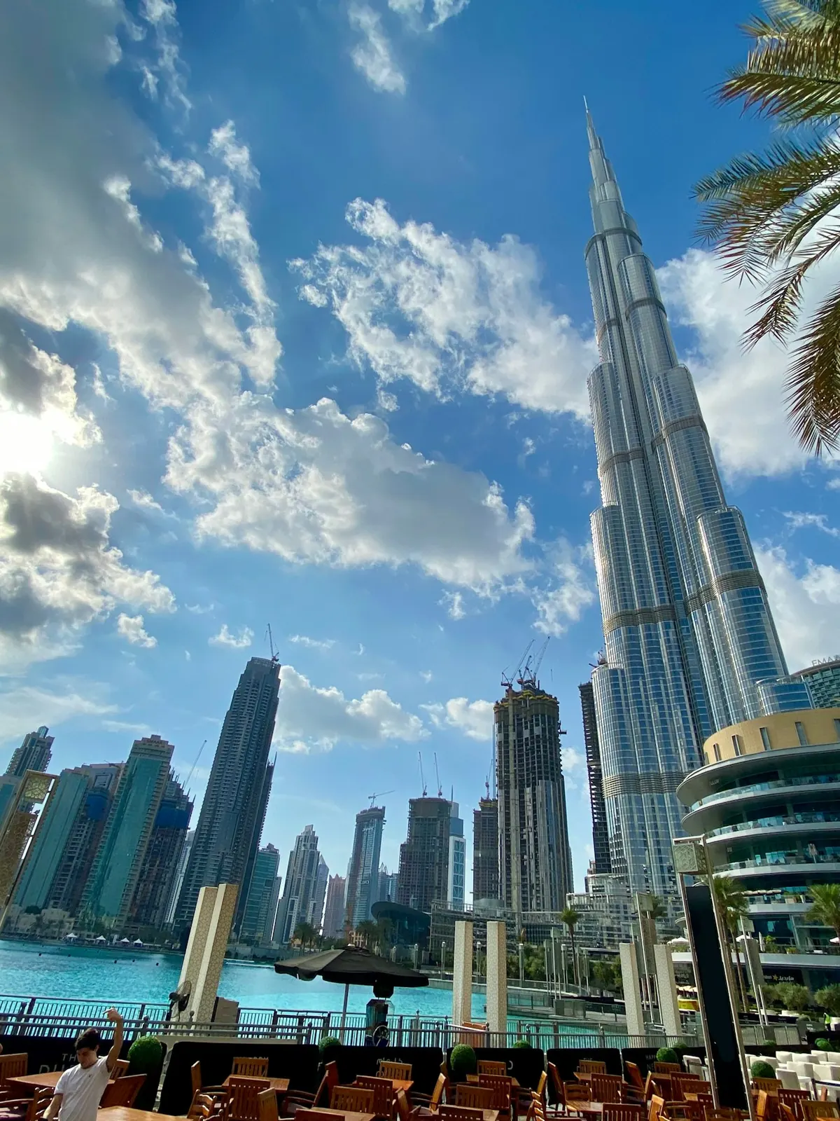 Burj Khalifa rising above palm trees and glass towers in Downtown Dubai