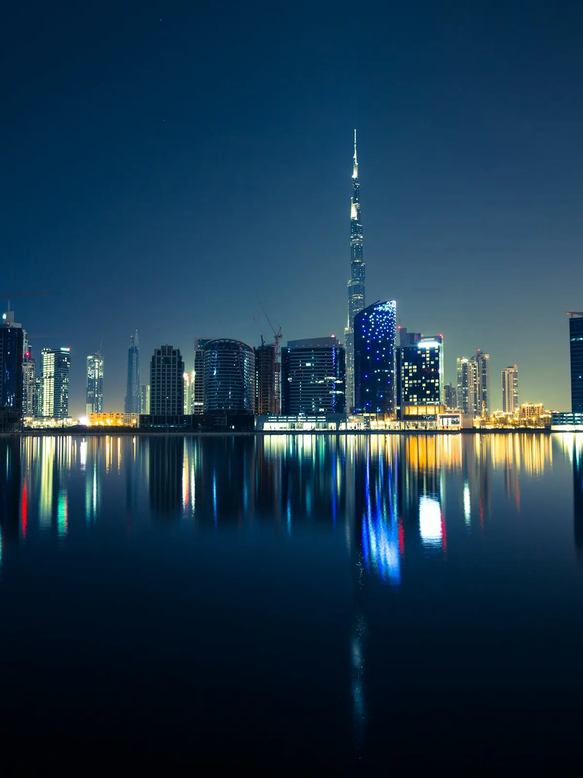 Dubai's skyline reflected in still water at night